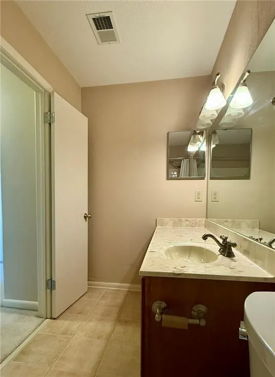 Bathroom with vanity, a textured ceiling, and light tile patterned floors