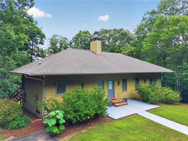 Single-story residence featuring a gray asphalt shingle roof and light yellow siding