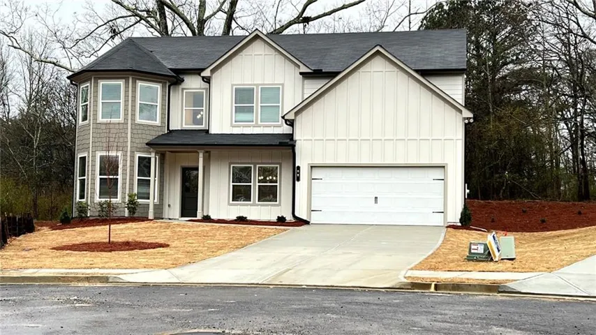 Newly constructed residence featuring a two-story design with a prominent two-car garage