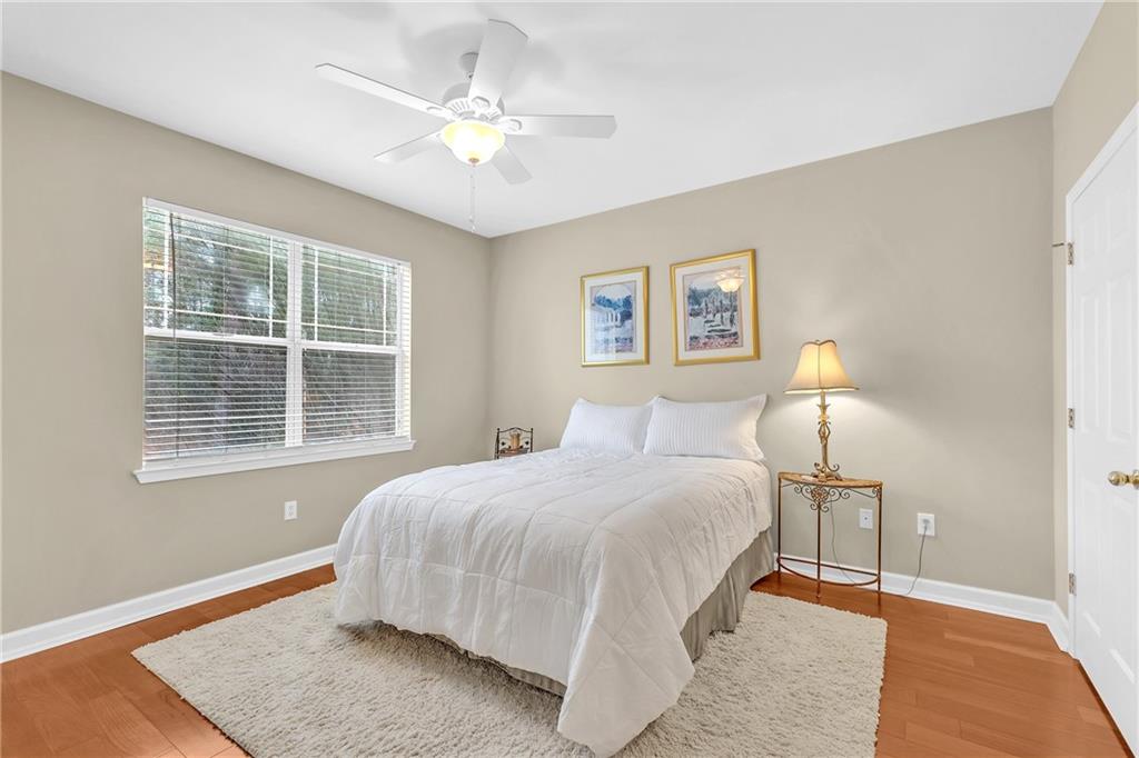Bedroom with hardwood / wood-style floors and ceiling fan