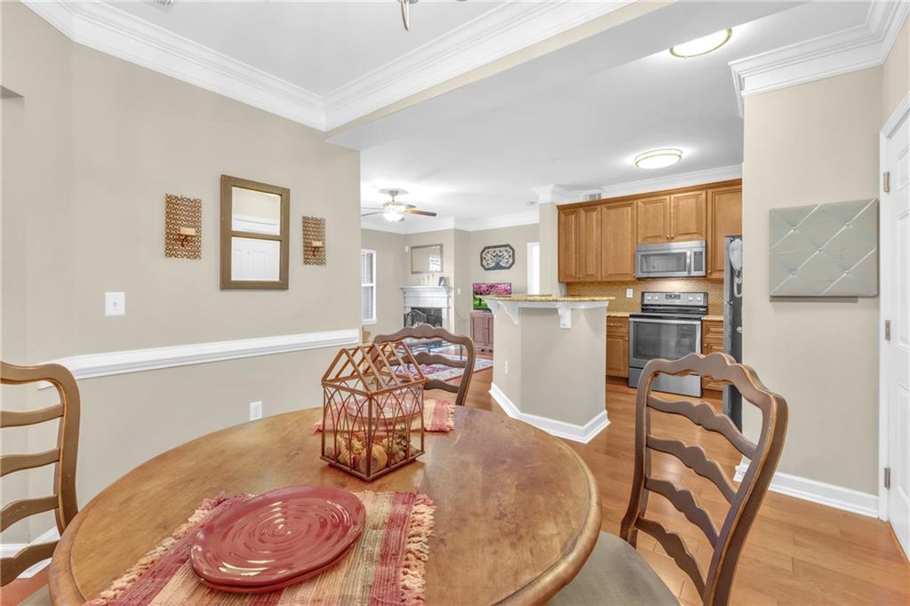 Dining room with light hardwood / wood-style flooring, crown molding, and ceiling fan