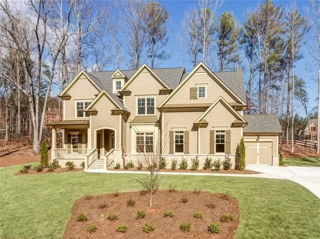 Craftsman inspired home with a garage, a porch, and a front yard