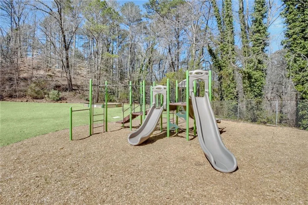 Community play area with fence and a yard
