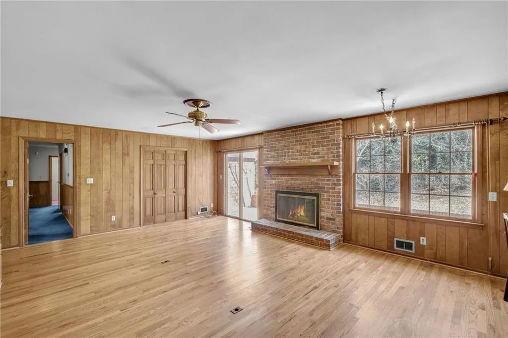 Unfurnished living room featuring a healthy amount of sunlight, light wood finished floors, and visible vents