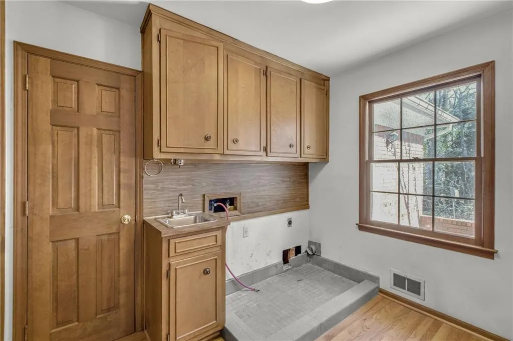 Laundry area with hookup for a washing machine, a sink, visible vents, cabinet space, and electric dryer hookup