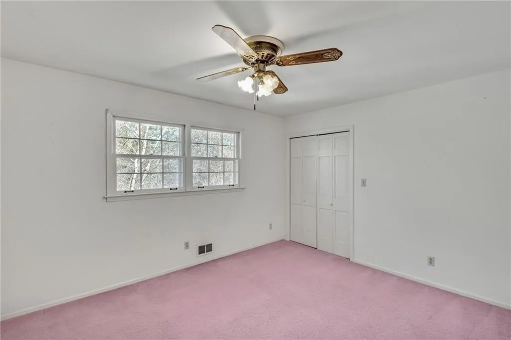 Unfurnished bedroom with light carpet, baseboards, visible vents, a ceiling fan, and a closet