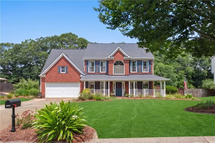 Brick front with inviting wrap around, covered porch