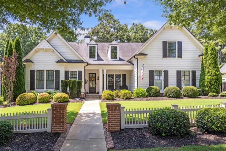 White siding facade with black shutters and a covered front porch