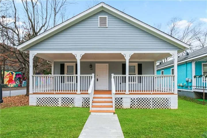 Bungalow-style home with covered porch and a front lawn