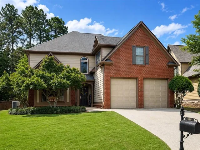 Traditional-style residence featuring a brick and siding exterior