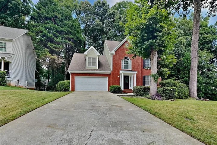 Red brick exterior with white trim, a gabled roof, and an arched window above the front entry