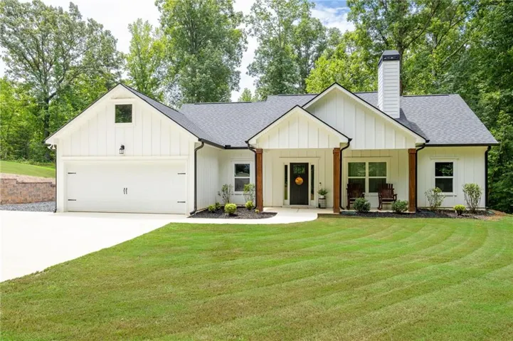 White board and batten exterior with dark shingle roofing