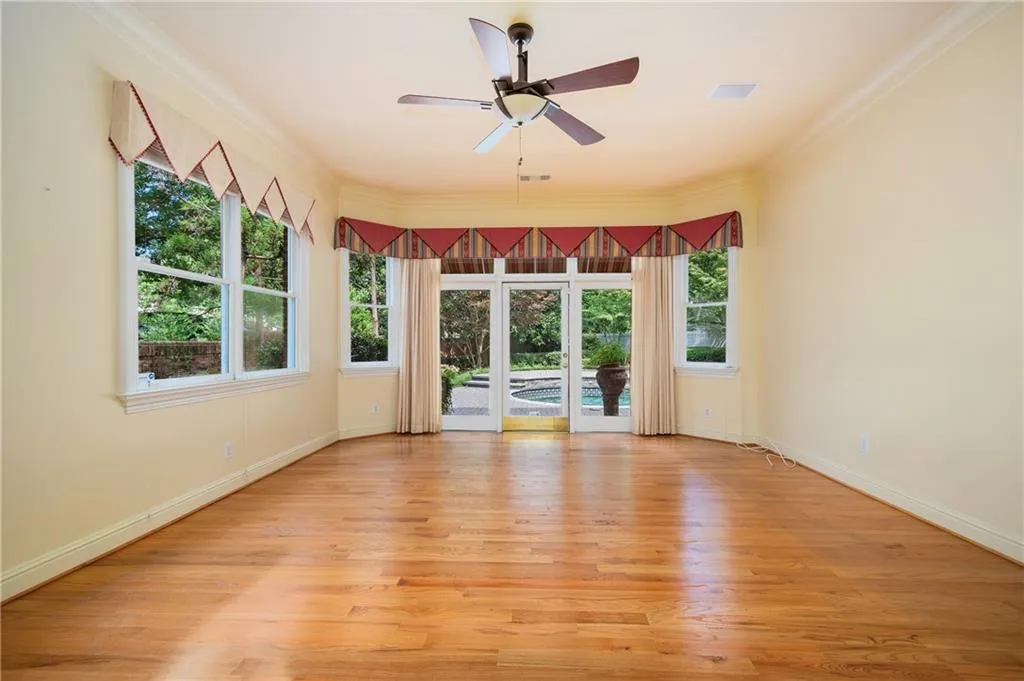 Primary bedroom with hardwood floors and access to the pool and courtyard