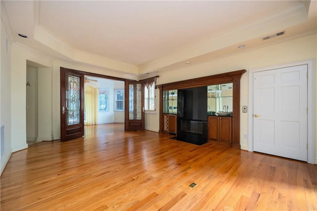 Fireside living room with wet bar and custom glass doors to sunroom