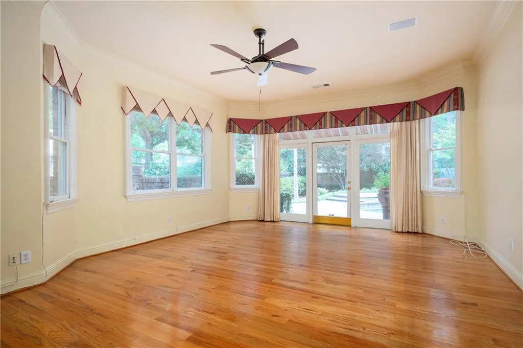 Primary bedroom with hardwood floors and access to the pool and courtyard