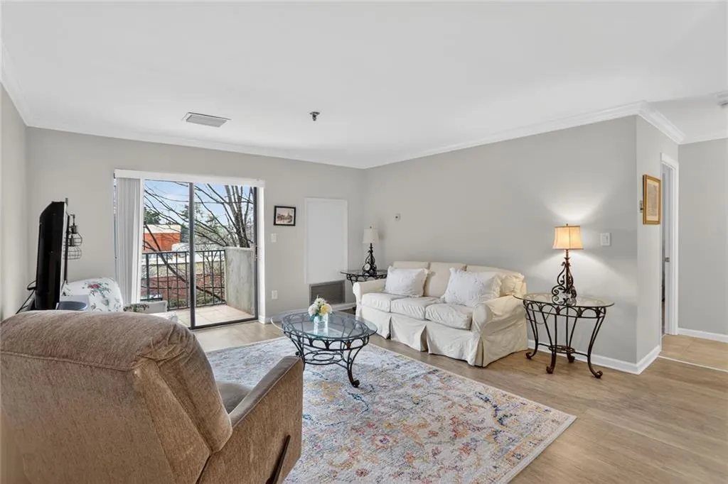 Living area with ornamental molding and light wood-style flooring