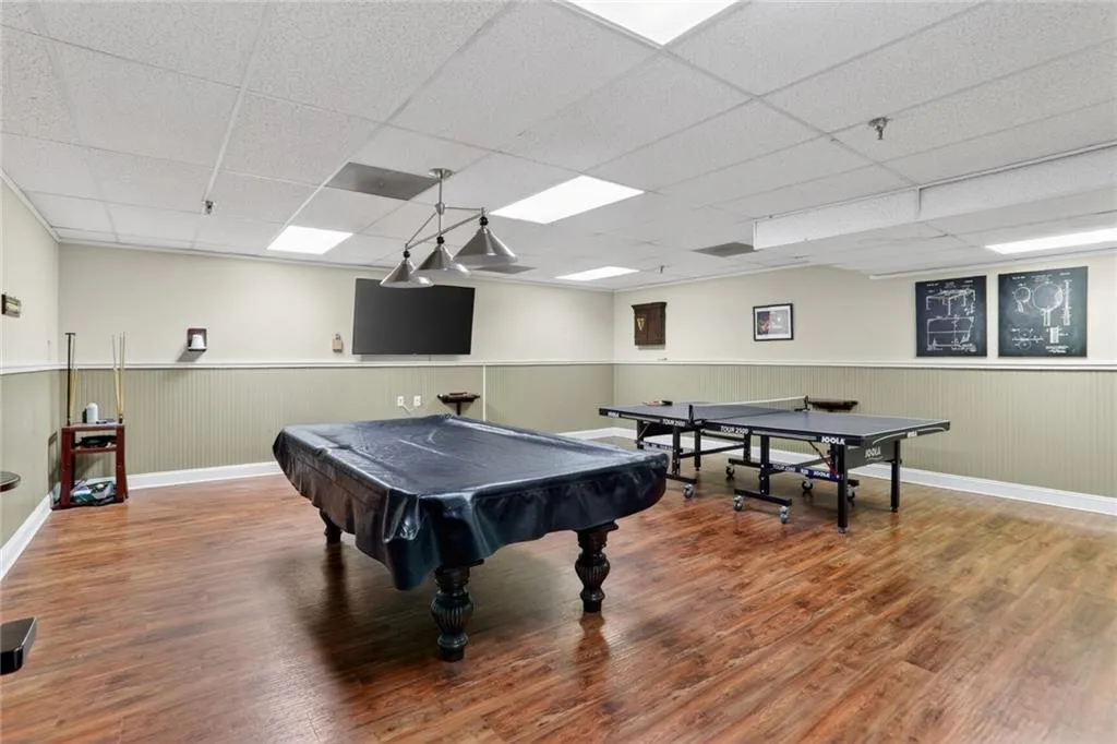 Game room featuring billiards, a paneled ceiling, and a wainscoted wall