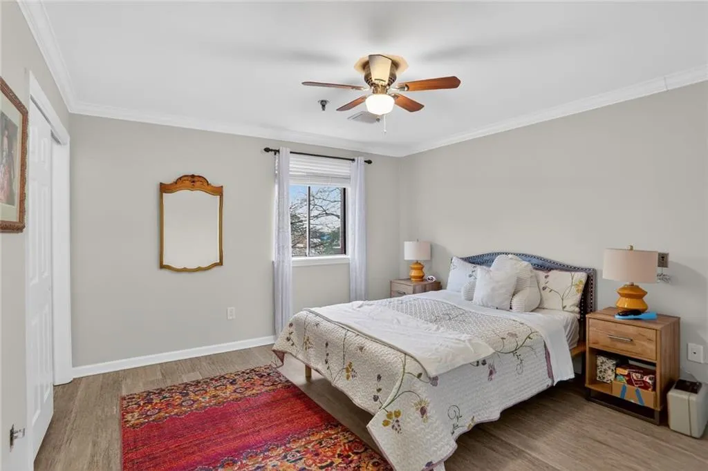 Bedroom featuring crown molding, light wood finished floors, and ceiling fan
