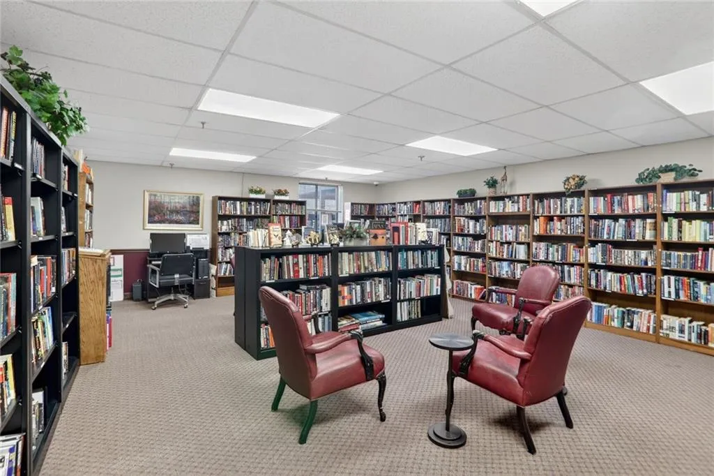 Living area featuring bookshelves and a paneled ceiling