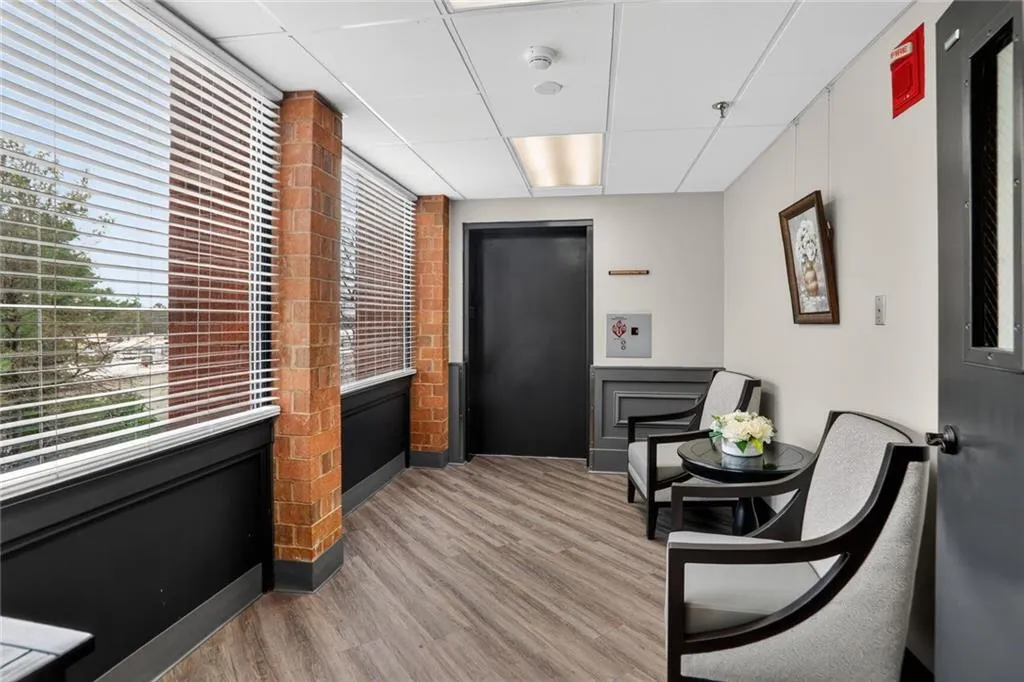 Living area featuring a paneled ceiling, plenty of natural light, and elevator
