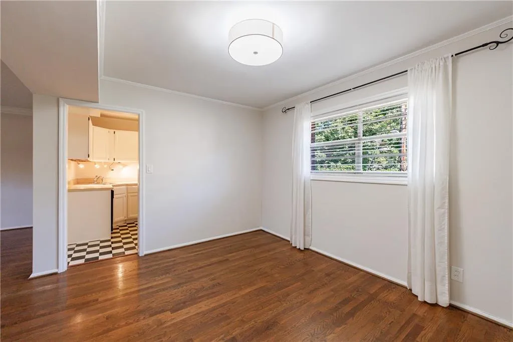 Empty room featuring crown molding and dark wood-style floors Empty room featuring crown molding and dark wood-style floors