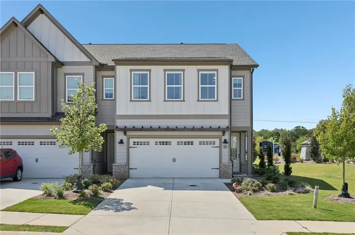 Craftsman-style home featuring board and batten siding, a shingled roof, driveway, and an attached garage