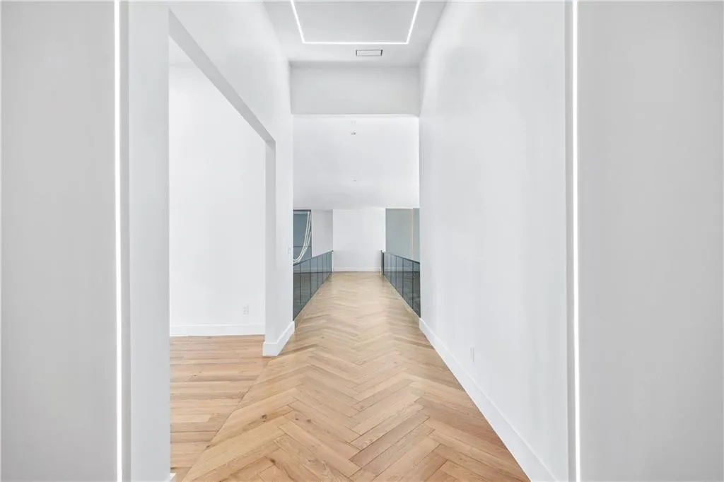 Hallway featuring baseboards and an upstairs landing