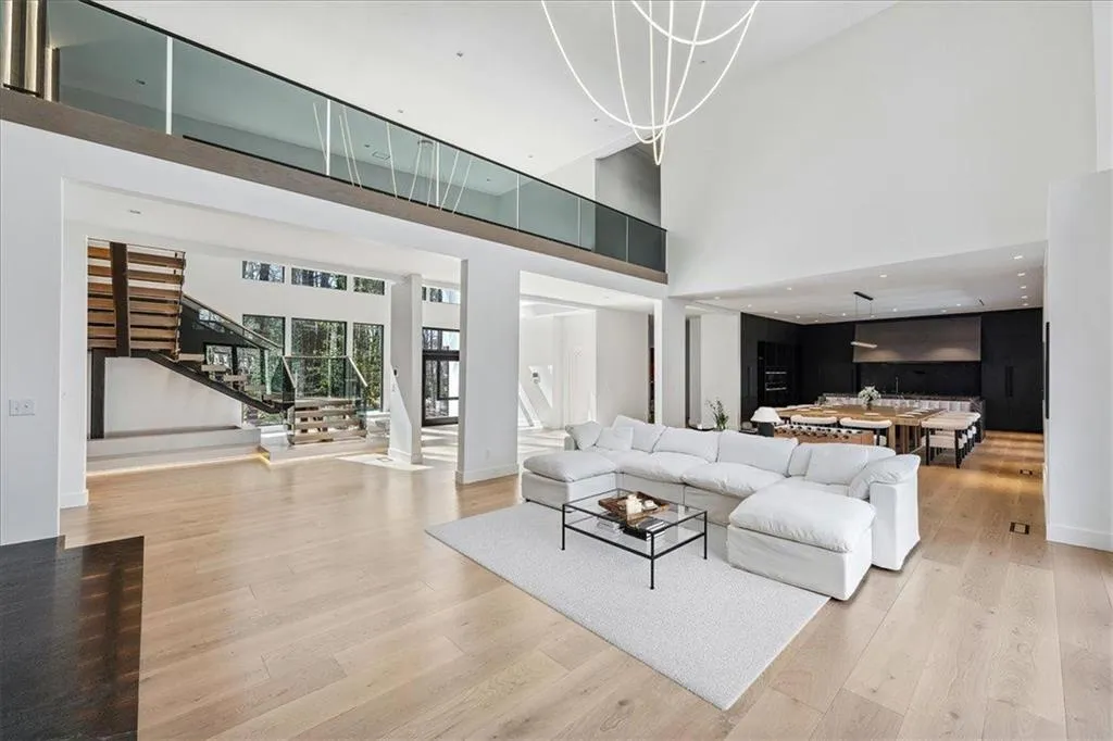 Living area with stairs, light wood-type flooring, and a high ceiling