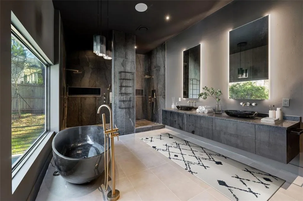 Bathroom featuring a freestanding tub, healthy amount of natural light, double vanity, and tile patterned floors