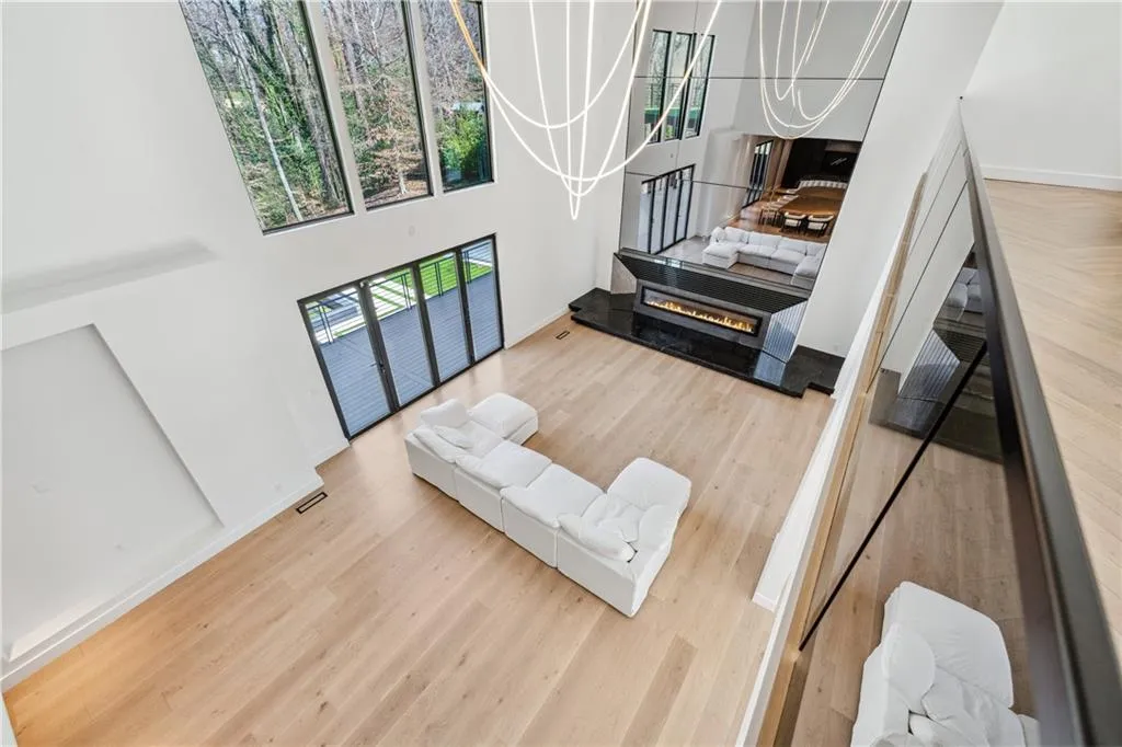 Living area featuring light wood-type flooring and a towering ceiling