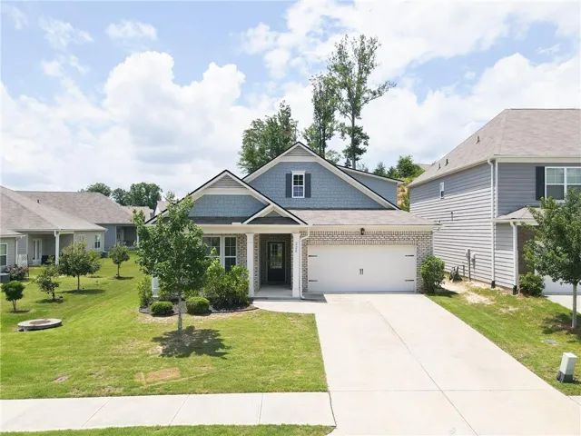 Contemporary residence featuring a two-car garage, partial brick and siding exterior, and a concrete driveway