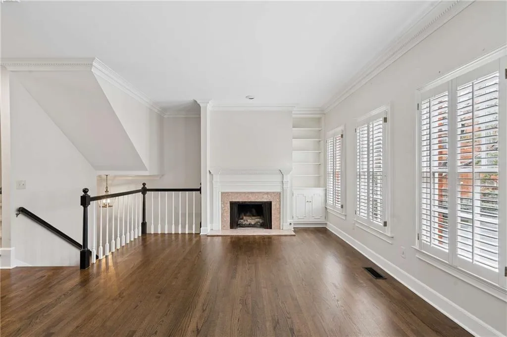 Fireside living room with built in shelves and wall of windows.