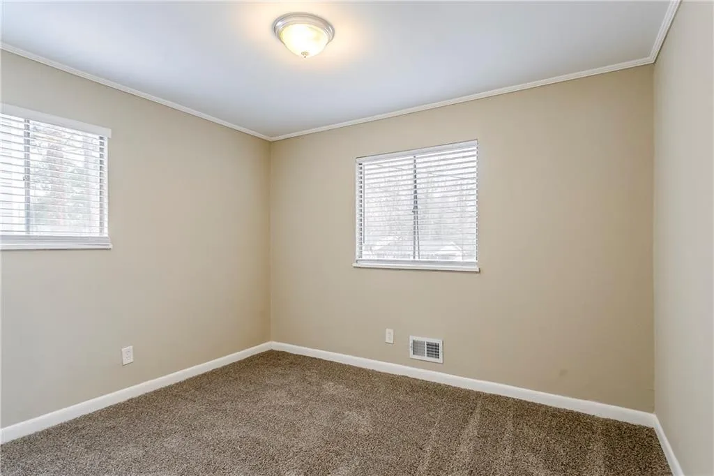 Carpeted empty room with ornamental molding