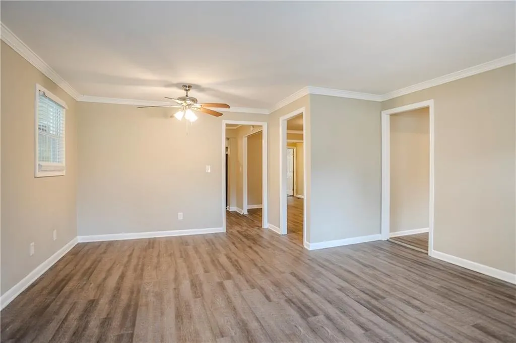 Empty room with crown molding, hardwood / wood-style flooring, and ceiling fan