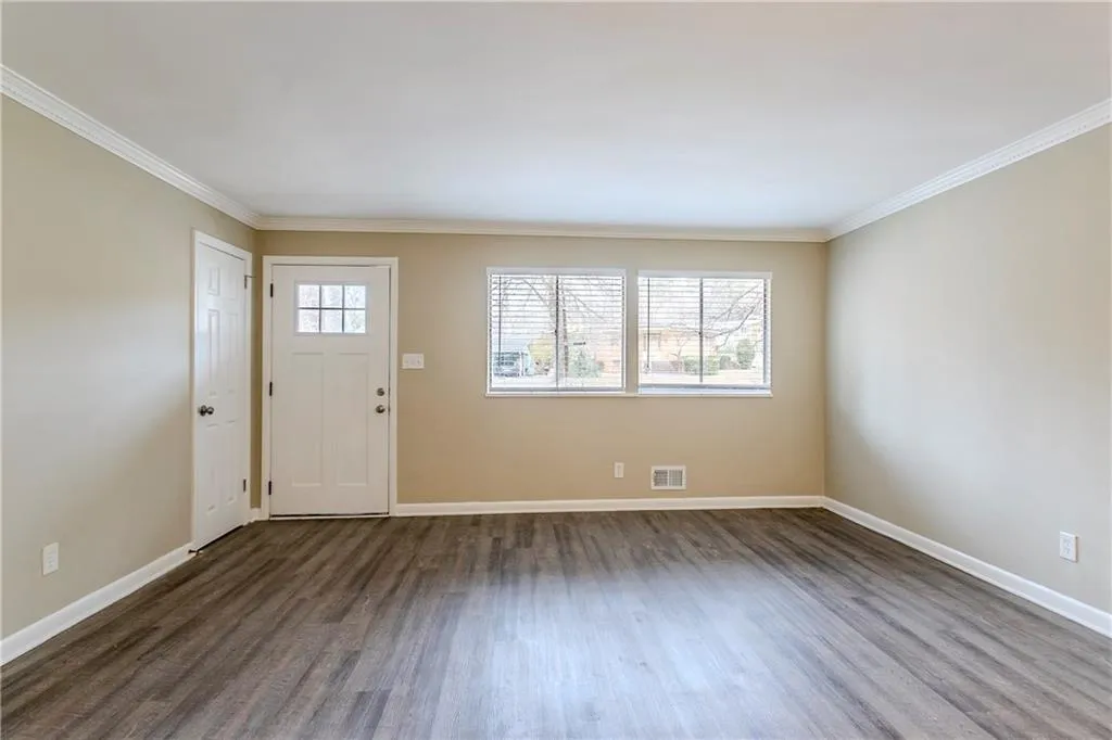 Foyer featuring crown molding and dark hardwood / wood-style flooring