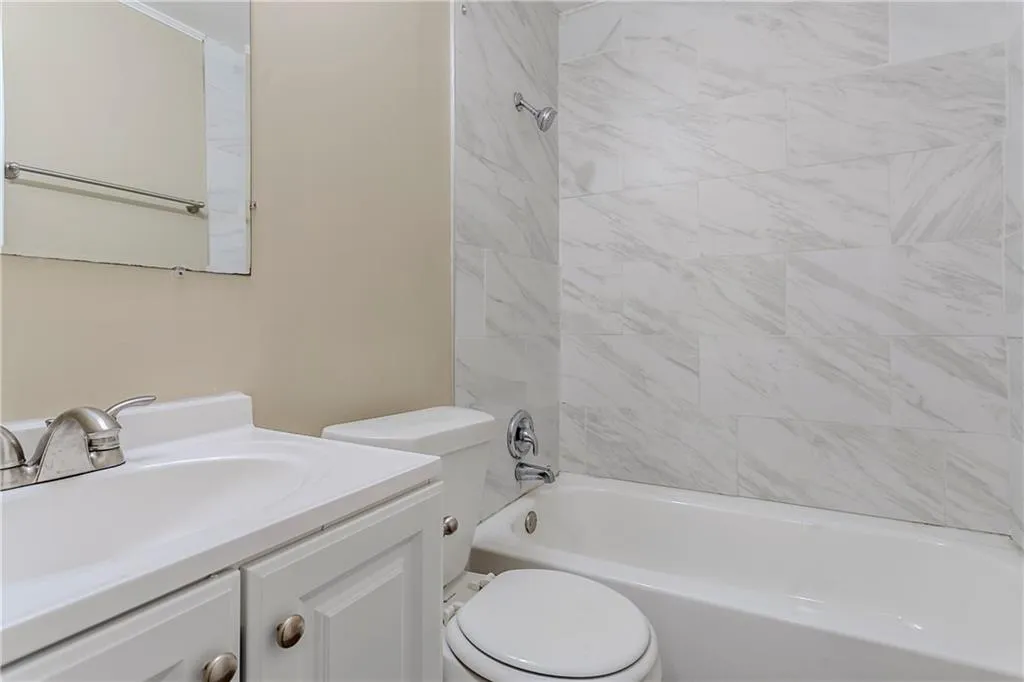 Full bathroom featuring toilet, vanity, and tiled shower / bath