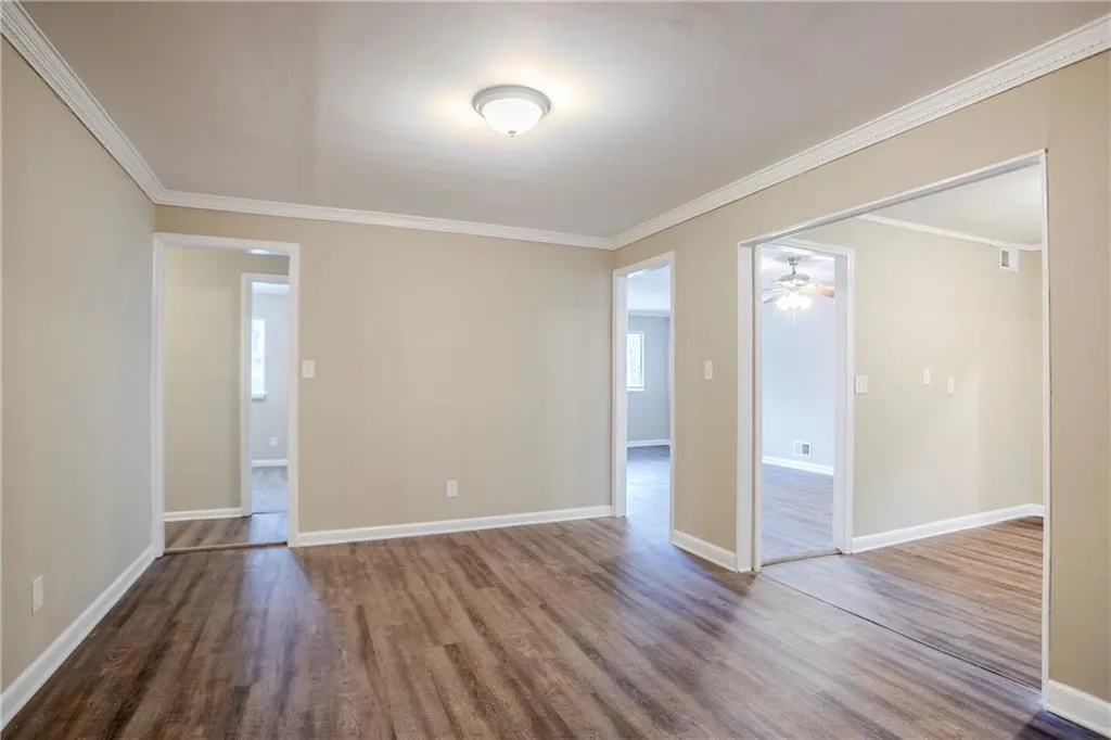 Empty room featuring hardwood / wood-style floors and ornamental molding