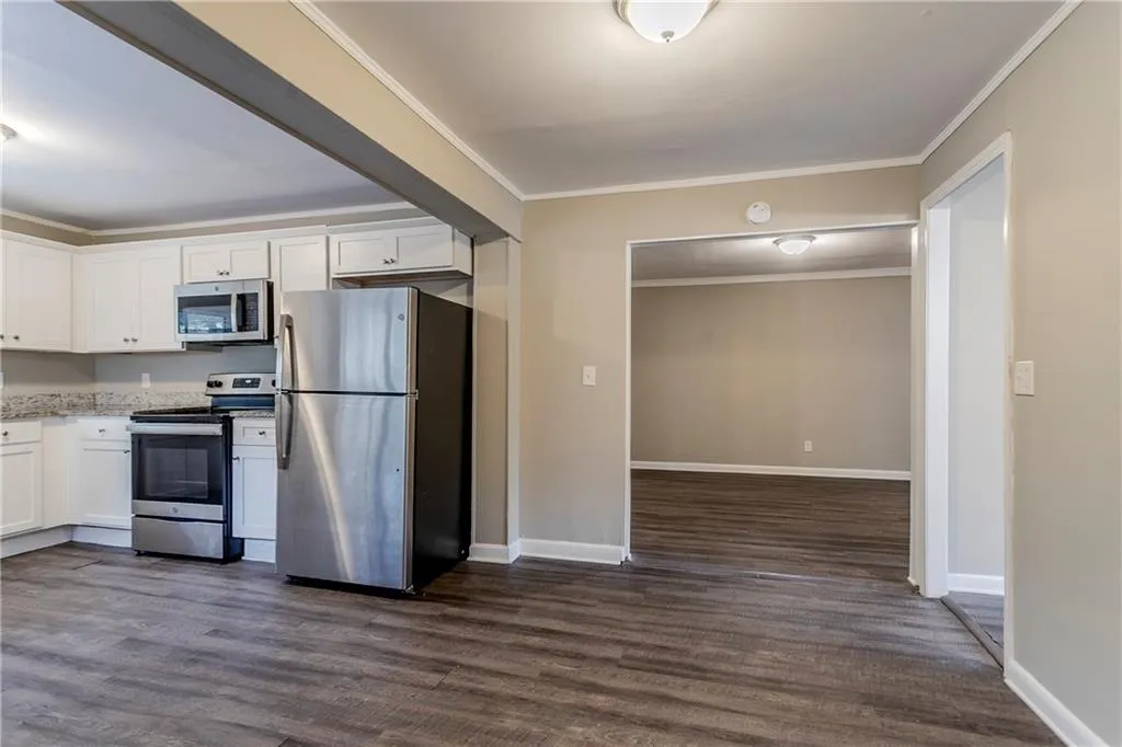 Kitchen featuring white cabinetry, dark hardwood / wood-style flooring, and stainless steel appliances