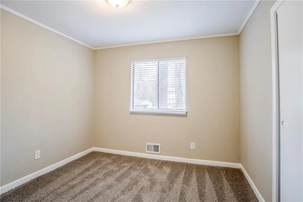 Unfurnished room featuring crown molding and carpet floors