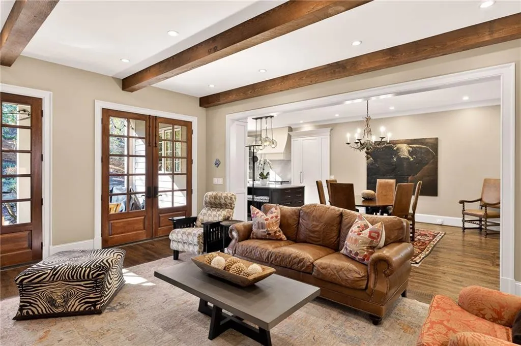 Living room featuring recessed lighting, wood finished floors, french doors, beam ceiling, and a chandelier