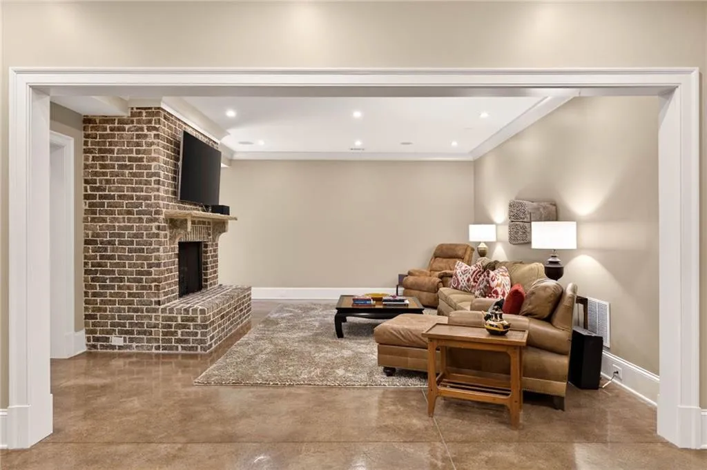 Living area featuring concrete flooring, recessed lighting, and a fireplace