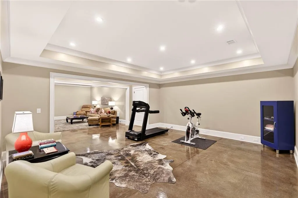 Workout area featuring finished concrete flooring, recessed lighting, and a raised ceiling