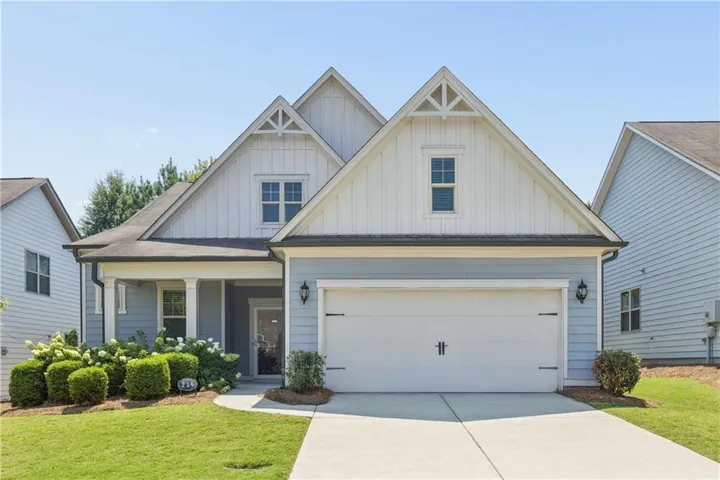 Craftsman-style exterior with gabled roof lines, light blue siding, white trim, a covered porch with columns, and a two-car garage