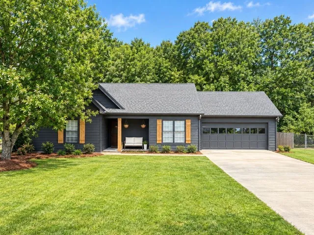 Charcoal exterior with light wood-tone shutters and porch columns