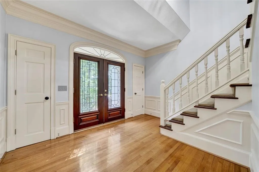 Foyer entrance featuring french doors, ornamental molding, and light hardwood / wood-style flooring