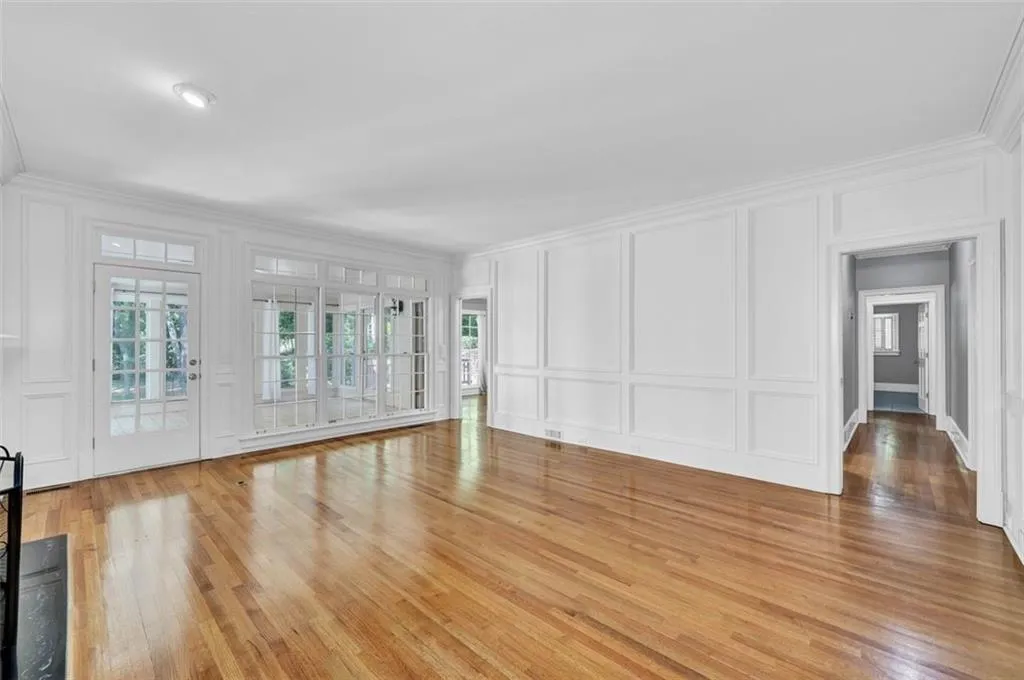 Unfurnished living room with ornamental molding and light hardwood / wood-style floors