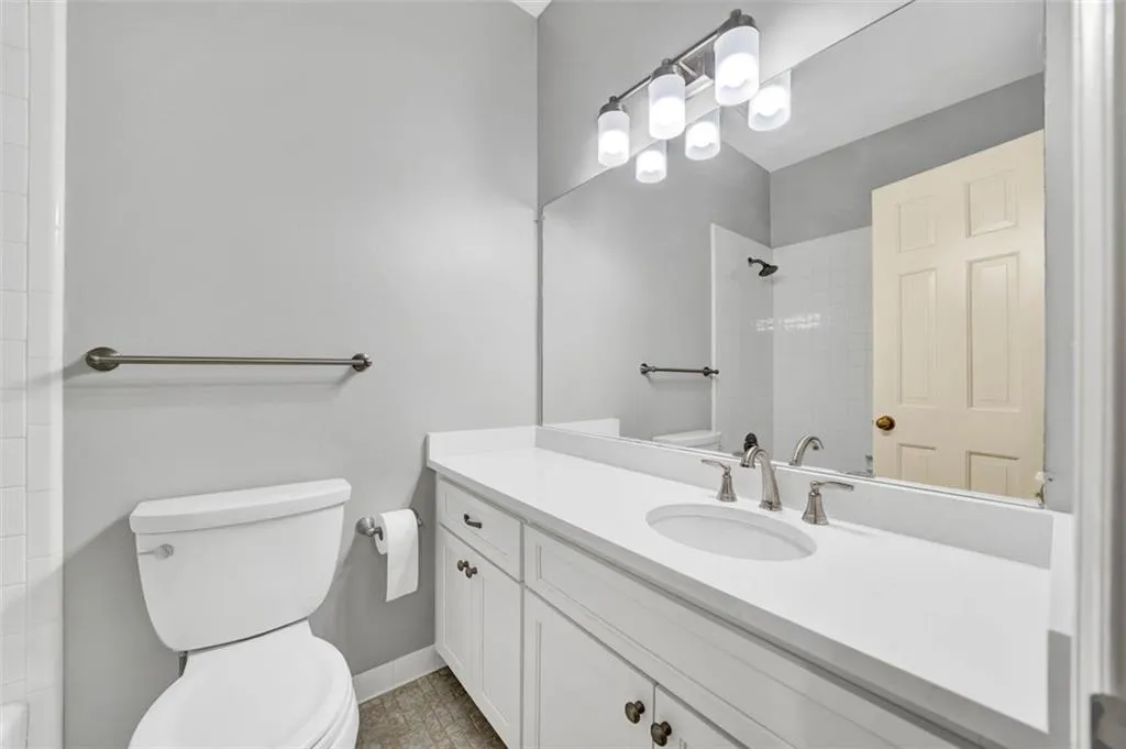 Bathroom with oversized vanity, toilet, and tile floors