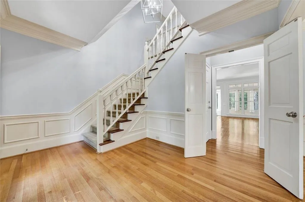 Staircase with ornamental molding and light wood-type flooring