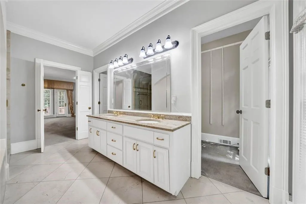 Bathroom featuring dual vanity, tile flooring, and crown molding