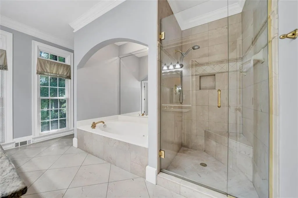 Bathroom with crown molding, plus walk in shower, and tile floors